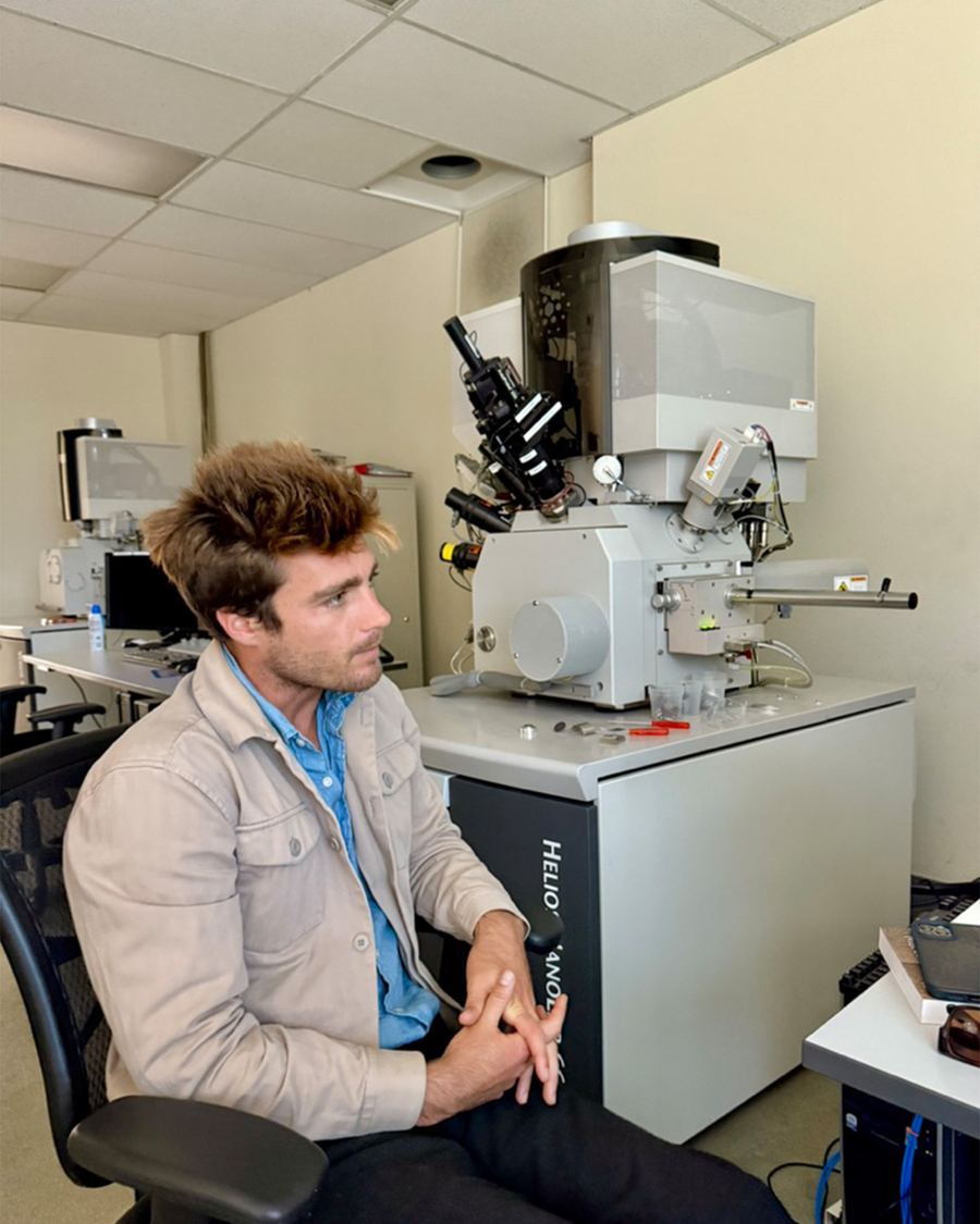 Trevor Hawke beside a scanning electron microscope